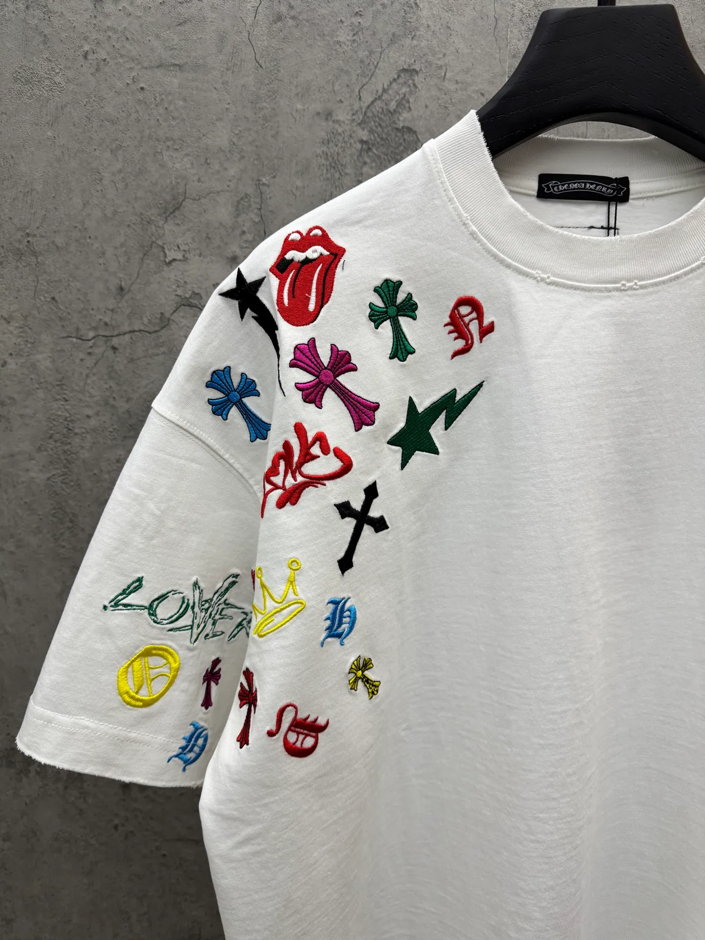 P240 top version, real shot without P, ​​different from market currency) 𝗖𝗵𝗿𝗼𝗺𝗲 𝗛𝗲𝗮𝗿𝘁𝘀/Cro Heart 2026 Spring New Original Single Counter American Color Thread Embroidery Couple Short Sleeves 👑The highest version! Customized fabric 320 grams, best-selling model at the counter, very comfortable to wear. Accessories: original molded and authenticated collar label ➕ 100% silk wash water label. Genuine purchase-grade original hangtag➕matching hanging rope➕3D hanging beads➕original packaging bag. Craftsmanship: The original version has consistent wiring! The highest version of the armhole matching technique! Color: White Black Size: S M L XL Style No.: 5211
